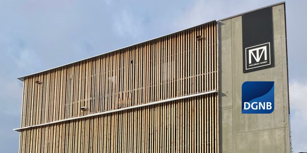 Moderne Gebäudefassade mit vertikaler Holzlattung und Sichtbeton, minimalistisches Logo auf der rechten Seite – Beispiel für nachhaltige, zeitgemäße Architektur mit klarem Designanspruch.